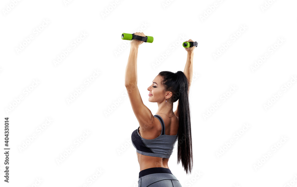 Φωτογραφία View from the back to a fitness woman holding dumbbells and raising her arms up isolated on white background