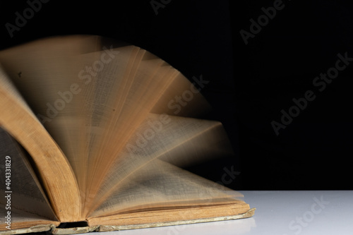 defocused photo of an ancient open book on black background