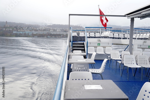 Swiss federal flag blowing in the wind over Lake Zurich on a lake tourist ship.
