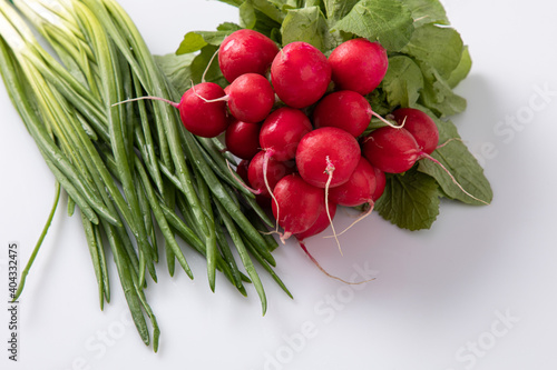 Bunch of reddish and spring onions fresh from the garden placed on white background 