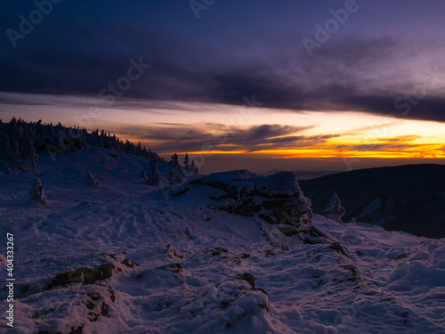 Harsh landscape on a mountain range of Jeseniky mountains, rock, clouds, sun, snow. Czech Republic. .