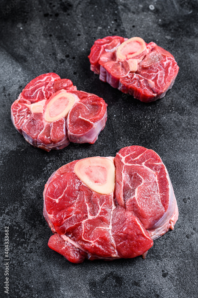 Fresh veal meat osso buco shank steak,  italian ossobuco. Black background. Top view