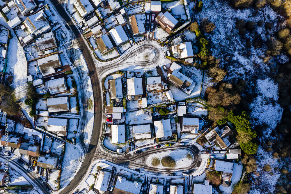 Fototapeta premium Aerial view of small residential streets covered in snow during winter