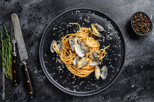 Seafood Spaghetti pasta with Clams vongole in a plate. Black background. Top view
