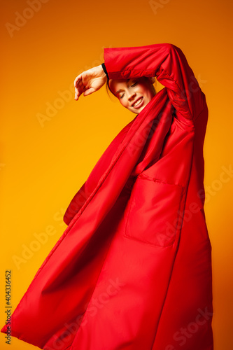 Female model in baggy coat and dancing