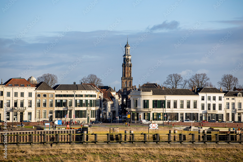 Wijnhuis tower at the central square in the background rising above the countenance city view of Hanseatic town in Gelderland province against a blue sky