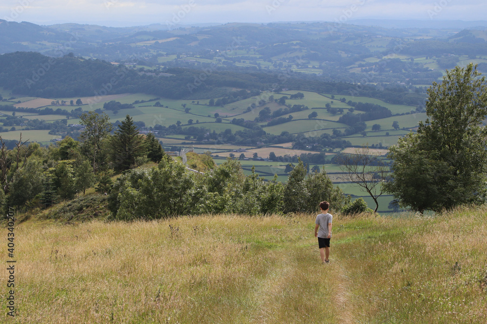 Boy walking across the hills in the countryside