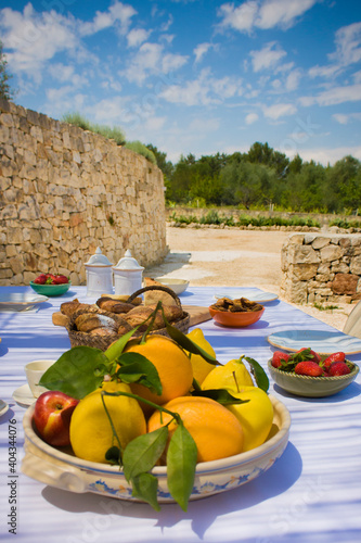 Schilderij op canvas Breakfast table - Sumptuously laid outdoor table with sweets and fruits