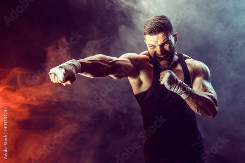 Sportsman boxer fighting on black background with shadow. Copy Space. Boxing sport concept. Smoke on background