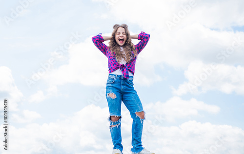 Confident beauty. portrait of pretty child girl. concept of future. happy childhood. cheerful teen girl has long curly hair. kid smiling outdoor. kid fashion and beauty. sense of freedom