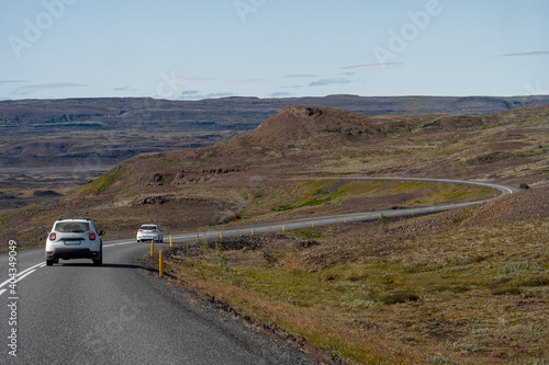 Gravel road with cars and blue sky in southern fjords, Iceland