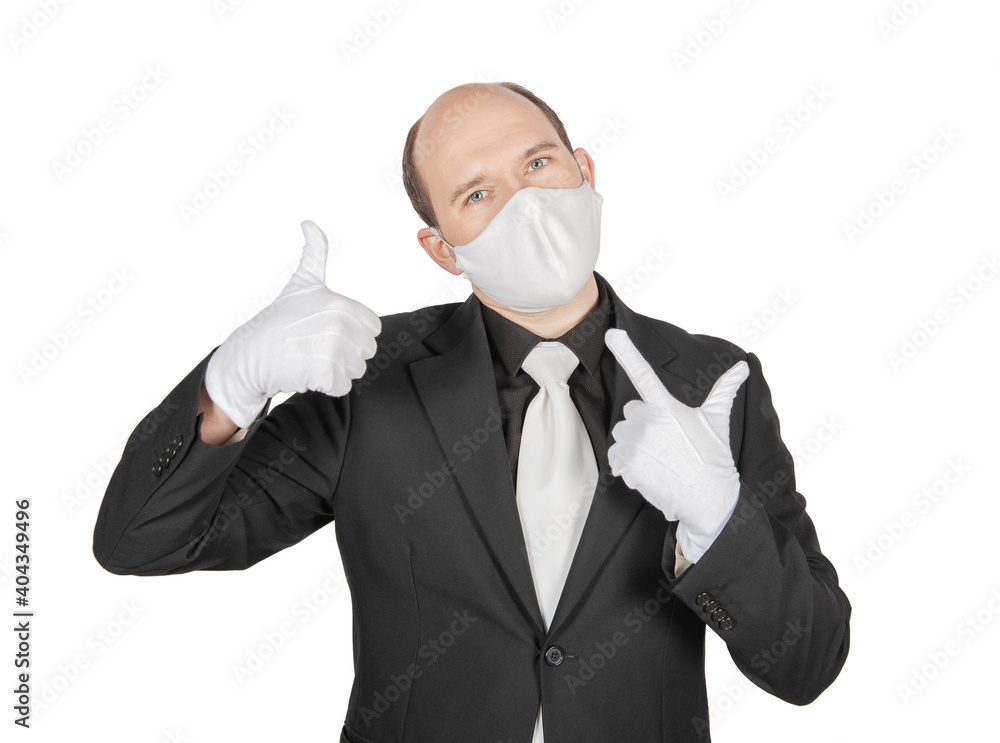 Handsome young business man holding surgical medical virus protection mask with white gloves showing thumbs up isolated Handsome young business man holding surgical medical virus protection mask with white gloves showing thumbs up isolated