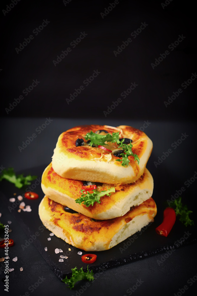 Mini pizzas in a column. Appetizing mini pizza presentation on a stone board. Healthy food. Mini pizzas in a column. Appetizing mini pizza presentation on a stone board. Healthy food.