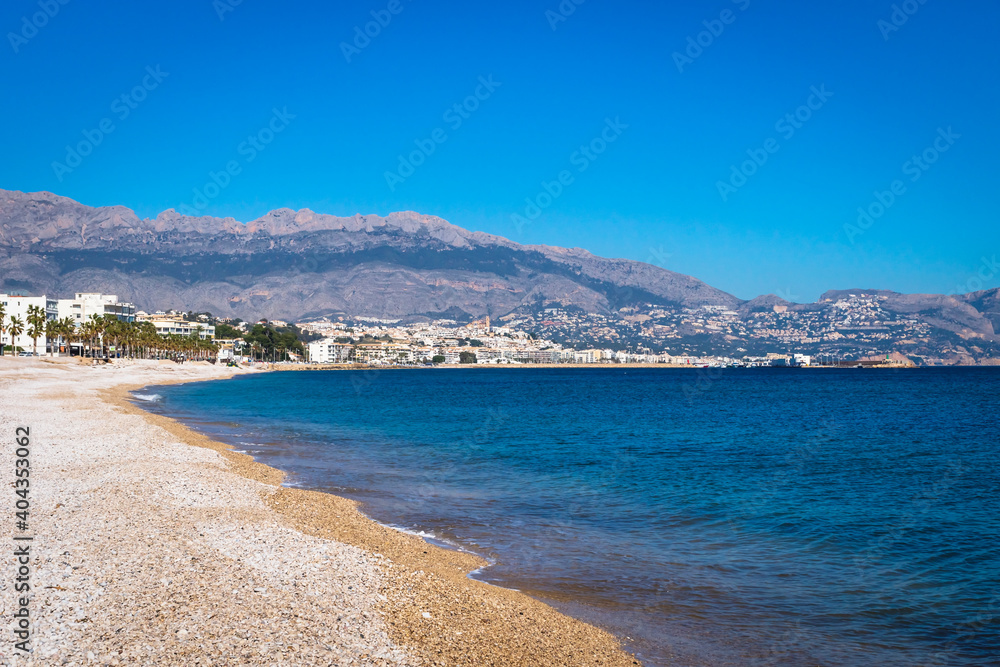 Stone beach along mediterrean sea with view to Altea seen from Albir, Spain