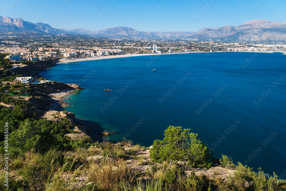 Panoramic view to the ocean bay of Albir with mountains in the background seen from natural park 'Serra Gelada' in Albir, Spain