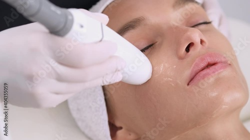 Apparatus cosmetology. Facelift device in beautician hand. Faceskin renovation. Non-surgical face lifting in beauty clinic. photo