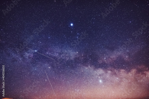 Universe with Milky Way and satellite in the night sky. © peizazas13