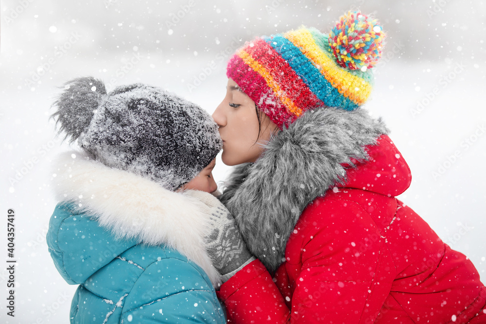 girl, older sister calms younger who cried after falling in the snow on a walk in the park girl, older sister calms younger who cried after falling in the snow on a walk in the park