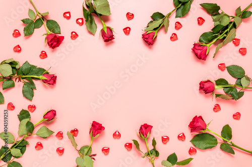 Pink Valentines day background with red roses and hearts and copy space in center. Birthday, Mother's, women's, Valentine's day or wedding celebration. Greeting card template. Top view, flat lay