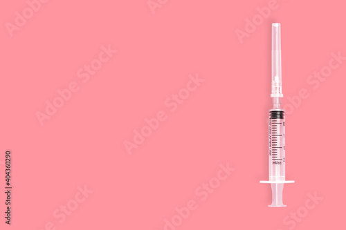 Medical plastic syringe on a red background.