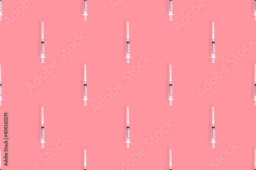 Medical syringes seamless pattern. Medical syringes on a red background.