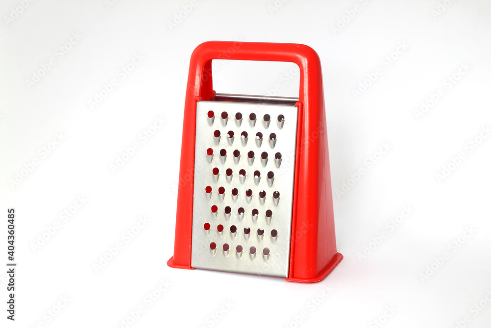 Red grater stainless steel closeup isolated on white background. Red grater stainless steel closeup isolated on white background.