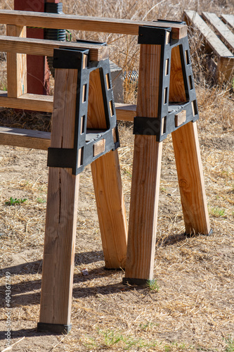 Two sawhorses made of wood and black plastic brackets