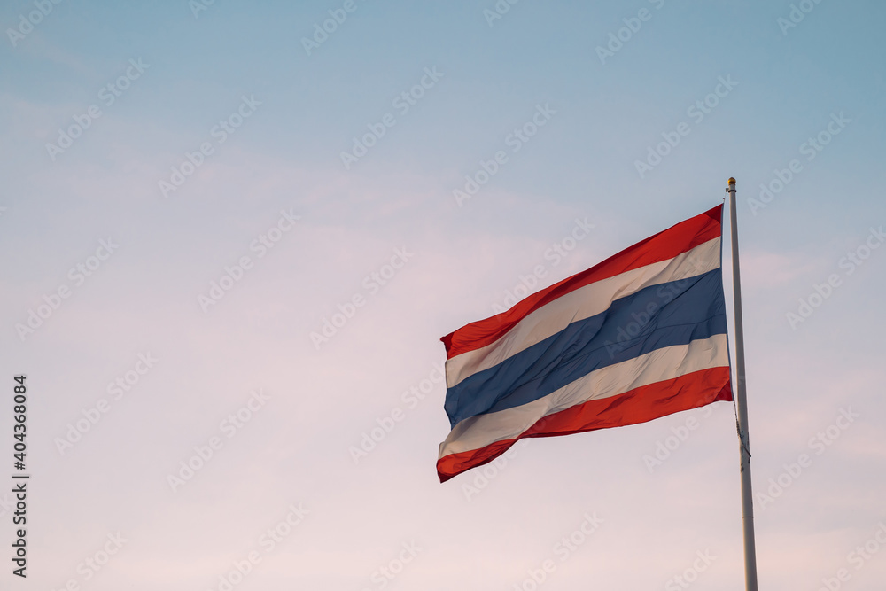 Thai flag fluttering with wind blow in clear sunset sky background with negative copy space - Kingdom of Thailand, Asian country in South East Asia