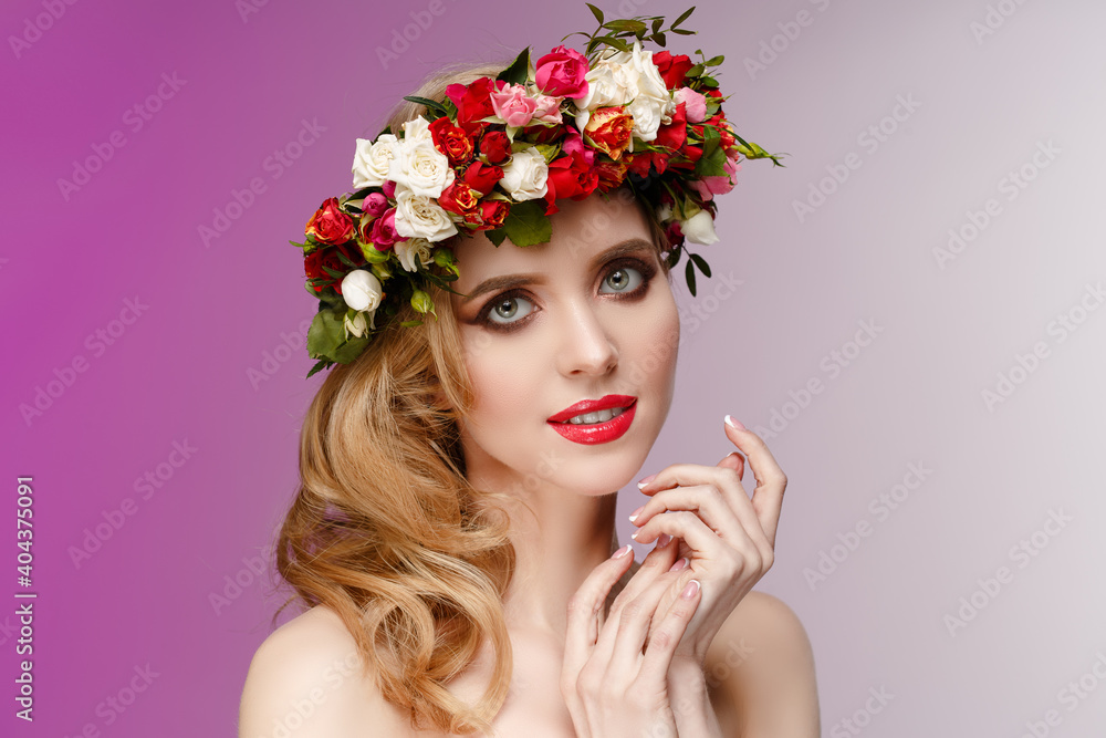 Fototapeta premium Girl in a wreath of spring flowers. Spring beauty. Woman with flowering plants in her hair.