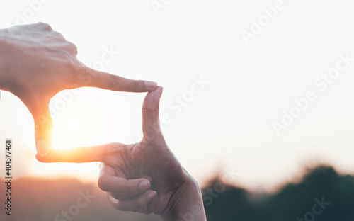 The woman making frame round the sun with her hands in sunrise,Future planning idea concept. photo
