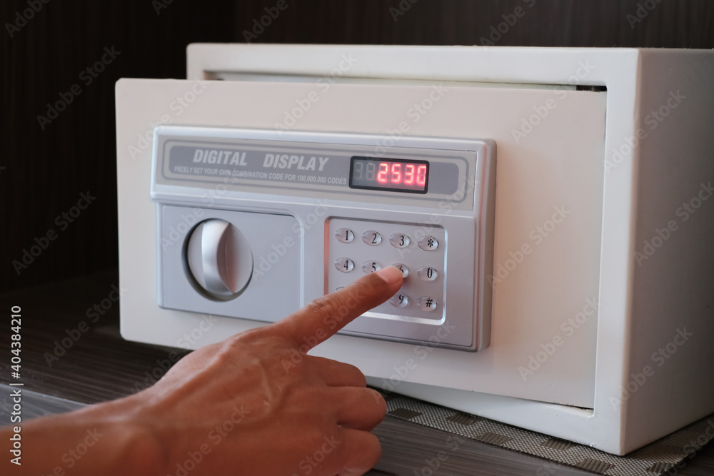 Close up hand opening small digital safe for home or office. Selected focus. Close up hand opening small digital safe for home or office. Selected focus.