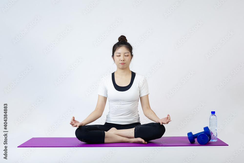 Fototapeta premium Asia woman sitting on yoga mat in lotus position on white background 