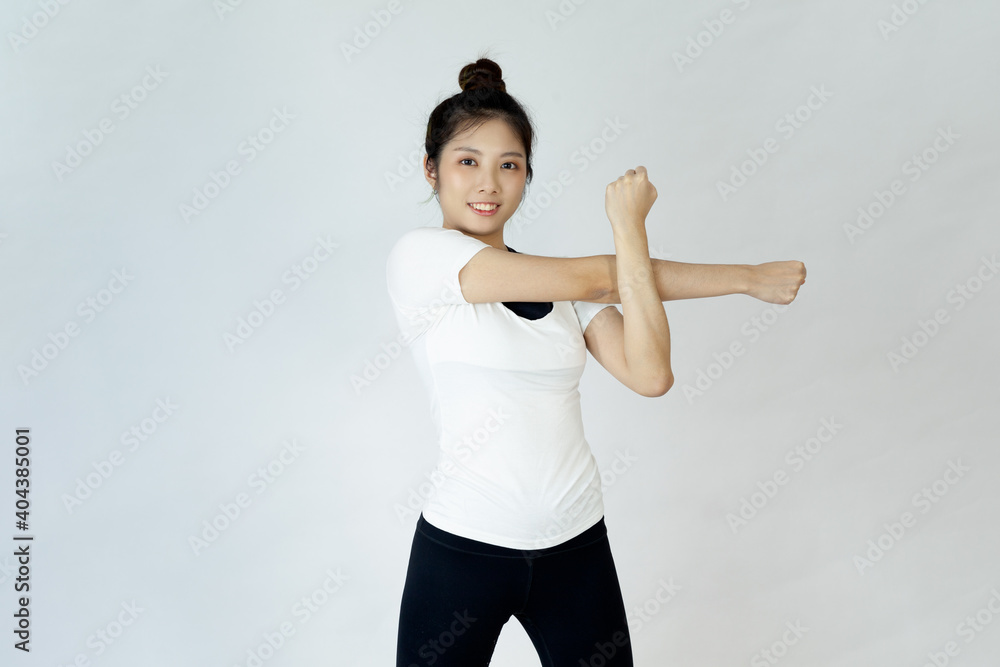 Smiling Asian woman doing yoga shoulder stretching on white background
Smiling Asian woman doing yoga shoulder stretching on white background