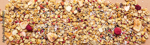 Granola with raspberries and white and black sesame seeds on a beige background close-up. Healthy food concept