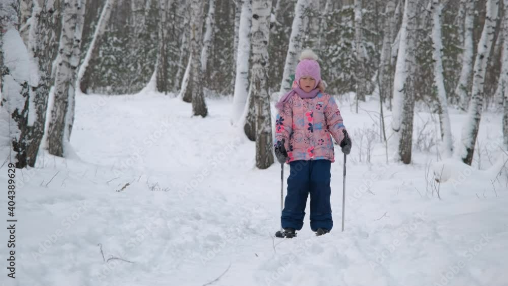 Cute Little Girl Cross Country Skiing in Snowy Park. Learning to Ski. Winter Sport Activities and Healthy Lifestyle Concept Cute Little Girl Cross Country Skiing in Snowy Park. Learning to Ski. Winter Sport Activities and Healthy Lifestyle Concept