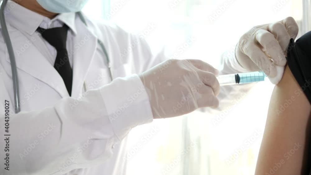 Doctor in mask taking vaccine with syringe Doctor in mask taking vaccine with syringe