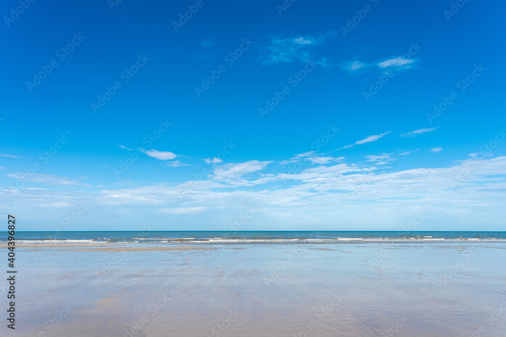 Sea beach and blue sky in sunny summer foreground.