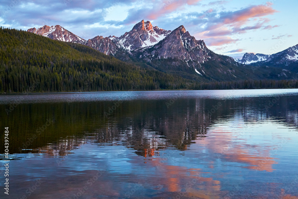 Mountain range at sunset reflecting in a glacial lake in the Rocky Mountains USA
