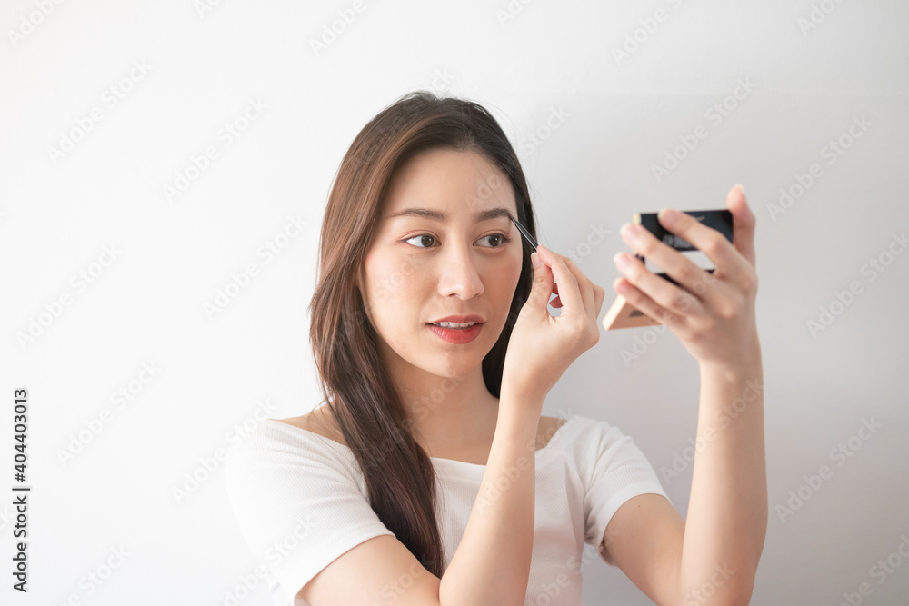 Eyeshadow applying concept, portrait of beauty young asian woman make up for eyes, eyebrow close up. Female look face with natural fashion style, holding the mirror, isolated on white background. Eyeshadow applying concept, portrait of beauty young asian woman make up for eyes, eyebrow close up. Female look face with natural fashion style, holding the mirror, isolated on white background.