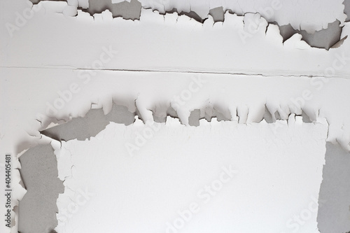 White color paint peeling off on ceiling house. Under the roof