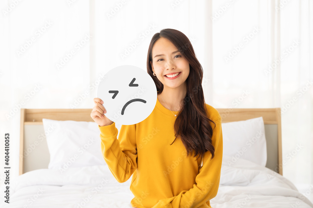 Asian beautiful woman happy and smile sitting on bed with holding paper sad emoticon symbol Asian beautiful woman happy and smile sitting on bed with holding paper sad emoticon symbol
