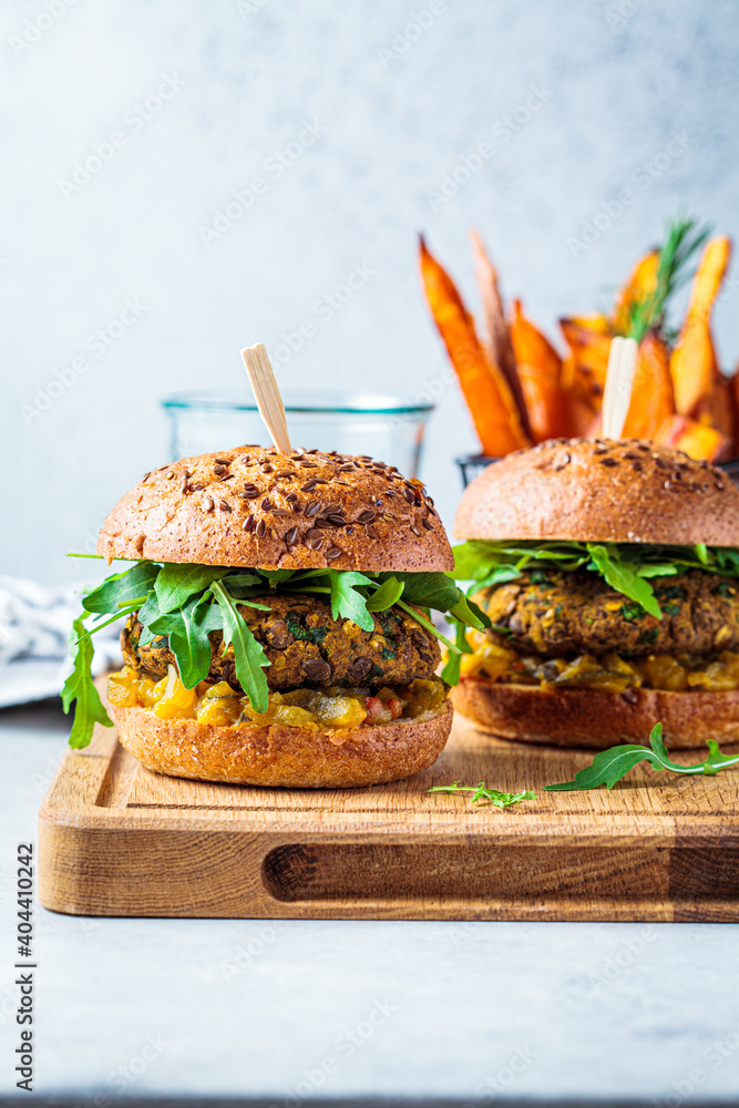 Φωτογραφία Vegan lentil burger with arugula, mustard sauce, fresh vegetables and sweet potato fries on wooden board