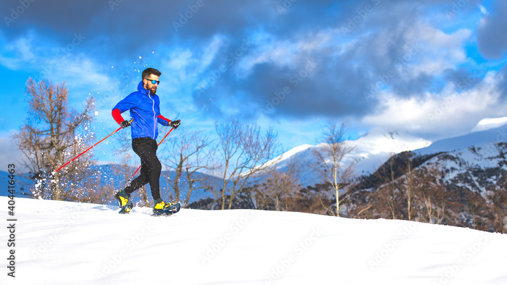Snowshoe tour a young sporty man alone