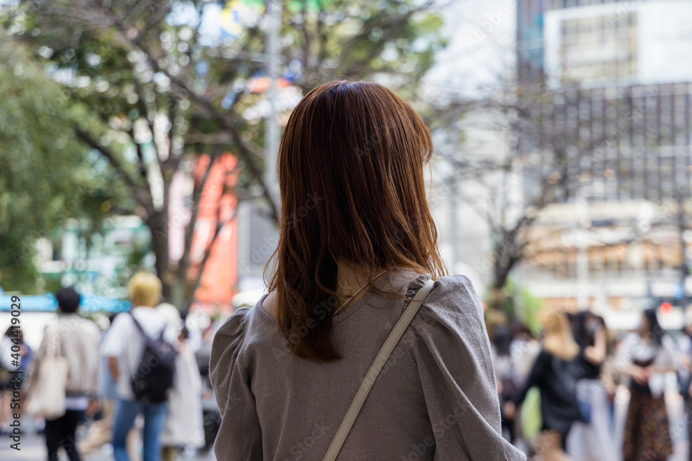 渋谷駅前に立つ女性の後ろ姿