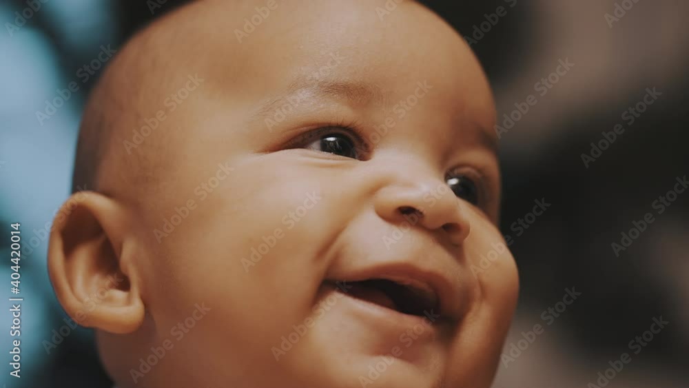 Portrait of adorable multiracial dark skin baby smiling. Slow motion. High quality 4k footage Portrait of adorable multiracial dark skin baby smiling. Slow motion. High quality 4k footage