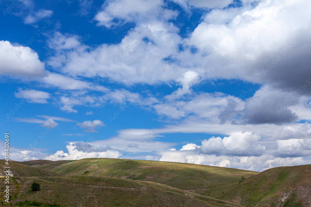 over the hills, clouds and blue sky
