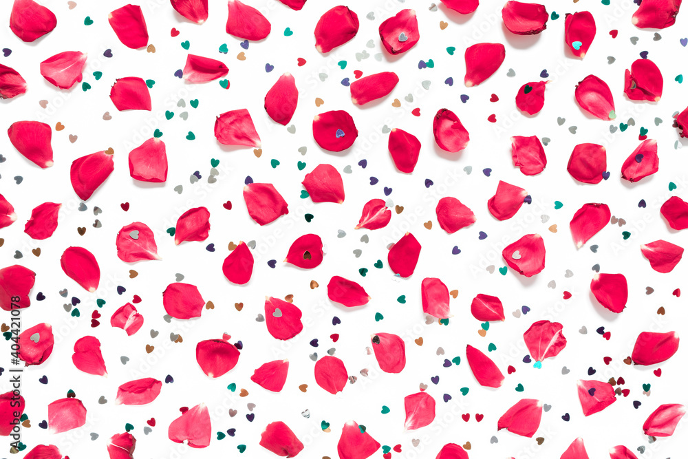 Rose petals and heart-shaped confetti are on a white background.  Floral layout for valentine's day, birthday, wedding invitation. Flat lay. Top view.