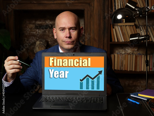High resolution hand holding card with written text Financial Year - closeup shot.
