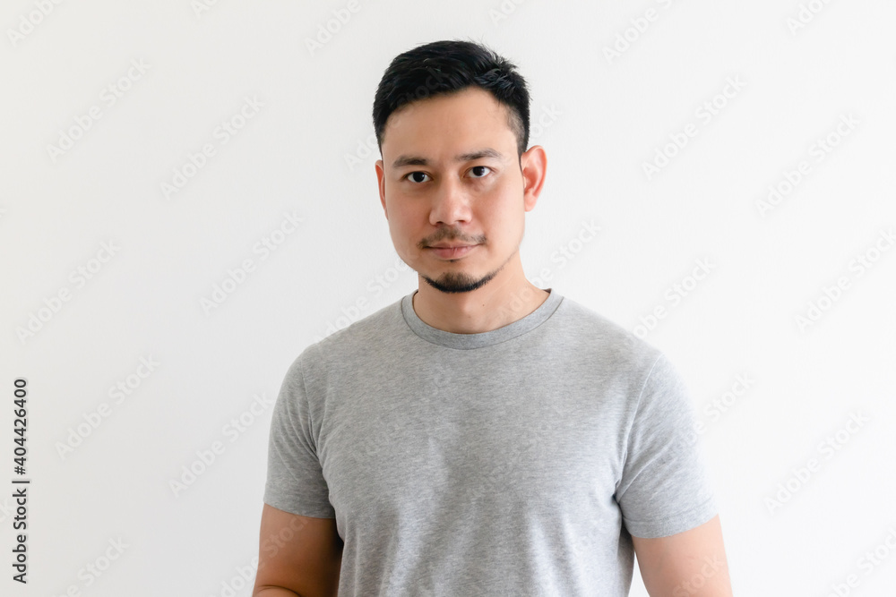 Obraz premium Happy and confident Asian man in grey t-shirt on isolated white background.