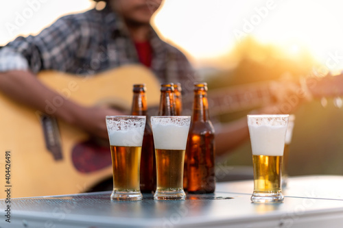 Men with Acoustic Guitar And Beer glasses and bottles in enironment photo